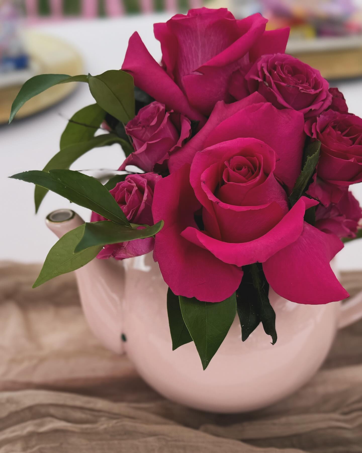 Hot pink rose arrangement in a pink teapot